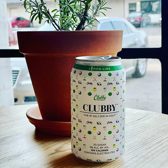 a can of beer sitting next to a potted plant