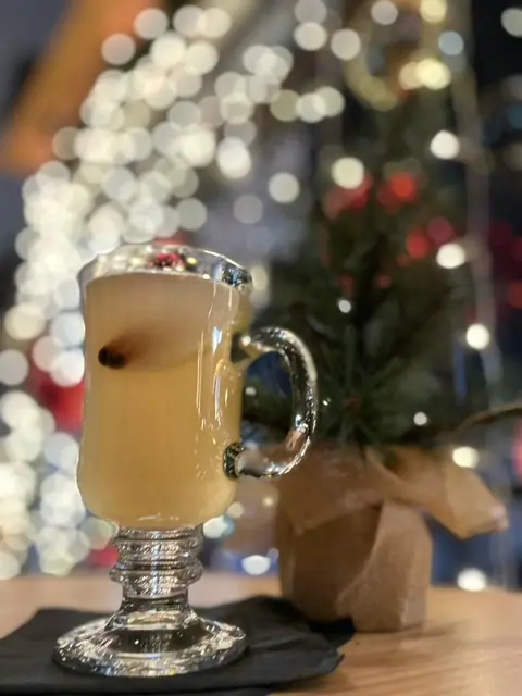 a glass of beer sitting on top of a table