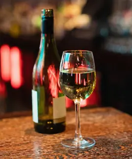 a glass of wine and a bottle on a table